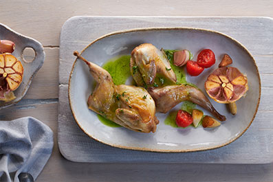 Codornices a la cazuela con aceite de hierbas y tomates confitados