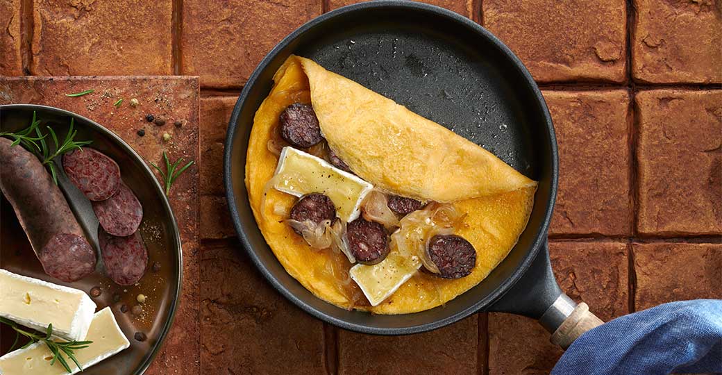 Tortilla abierta con butifarra negra, cebolla y queso brie