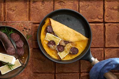 Tortilla abierta con butifarra negra, cebolla y queso brie